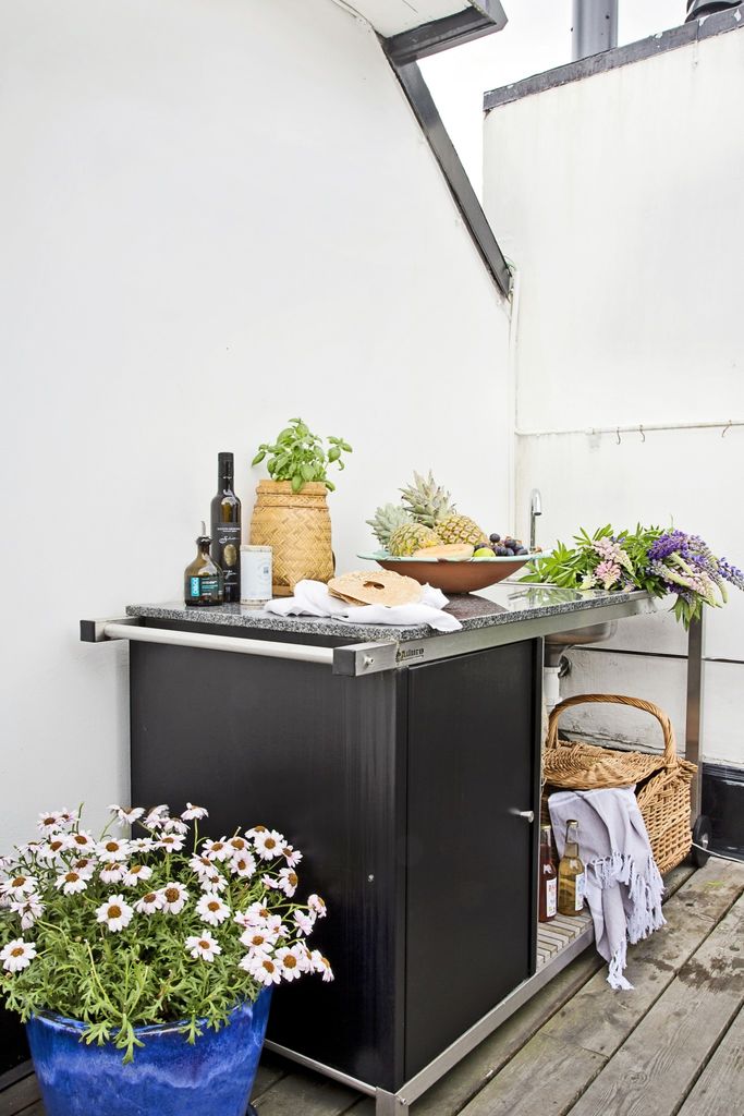 Med utsikt over sjøen og det urbane gatemiljøet ligger denne takterrassen flott til, innredet med materialer som kurv og tre, og detaljer i rosa og blått.